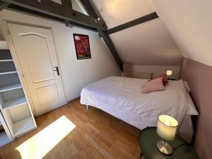 een kleine zolderslaapkamer met een bed en een kast bij Appartement des Vignes in Metz