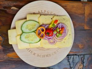 ブルクベルクにあるFerienhof Hierlの木製テーブルの上に並ぶチーズと野菜