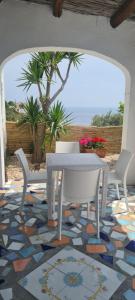 un tavolo bianco e sedie su un pavimento a mosaico di Casa Colomba Sant'Angelo a Ischia