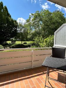 a fence on a patio with a table and a chair at Kurhotel Haus am Park in Erwitte