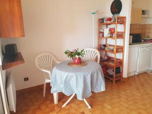 a table with a vase on it in a kitchen at Studio Le Lavandou, 1 pièce, 2 personnes - FR-1-308-183 in Le Lavandou