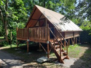 a large wooden cabin with a metal roof at Camping des Drouilhèdes in Peyremale +25 photos