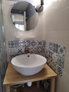 ein Badezimmer mit einem weißen Waschbecken und einem Spiegel in der Unterkunft Pavillon les pieds dans l'eau in Valras-Plage