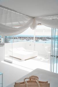 a white room with a bed and a large window at AVANTI Lifestyle Hotel - Only Adults in Corralejo
