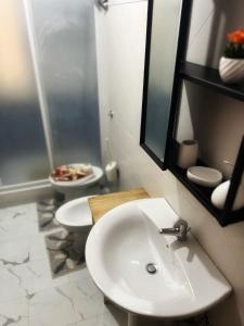 La salle de bains est pourvue d'un lavabo blanc et de toilettes. dans l'établissement Sognando il cilento, à Giungano