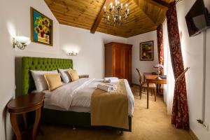 a bedroom with a bed with a green headboard at Carolina Heritage in Alba Iulia