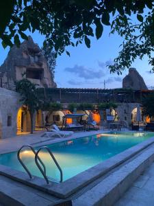 a swimming pool at a resort with a train in the background at Seven Rock Cave Hotel in Goreme