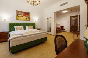 a bedroom with a large bed and a dining room at Carolina Heritage in Alba Iulia