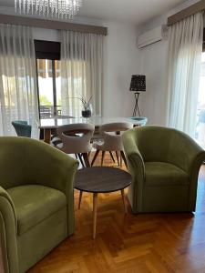 een woonkamer met 2 groene stoelen en een tafel bij Kouros Kalamitsa in Kavala