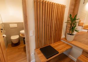 a bathroom with a toilet and a wooden divider at Ferienhaus Moselhöhe - 2023 neu renoviert, mit Design-Ausstattung & großem Garten in Traben-Trarbach +59 photos