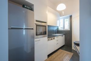 a kitchen with white cabinets and a refrigerator at Garden Villa Glyfada in Athens