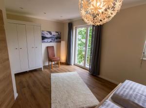 a living room with a chandelier and a large window at Ferienhaus Moselhöhe - 2023 neu renoviert, mit Design-Ausstattung & großem Garten in Traben-Trarbach