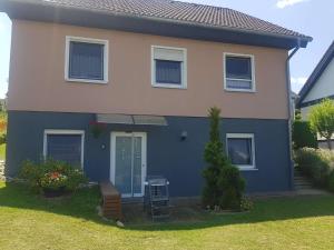 a blue and white house with a bench in the yard at Charlottenhöhe Apartment in Rottweil