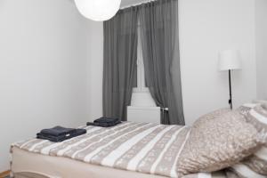 ein Schlafzimmer mit einem Bett mit zwei schwarzen Handtüchern darauf in der Unterkunft City Center Condo Vranje in Vranje