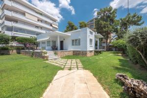 a house with a lawn in front of a building at Garden Villa Glyfada in Athens