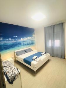 1 dormitorio con 1 cama y una pintura del océano en Da Mà en Tortora