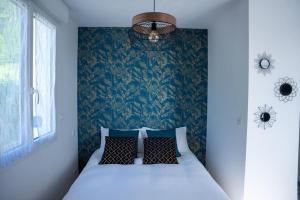 a bedroom with a bed with a blue wall at Pour une nuit douce 