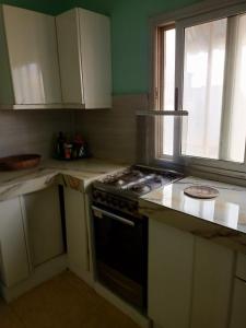 a kitchen with a stove top oven next to a window at Appartement 2 chambres Yoff Virage Dakar Senegal in Dakar
