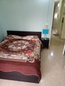 1 dormitorio con 1 cama con manta roja en Appartement 2 chambres Yoff Virage Dakar Senegal en Dakar