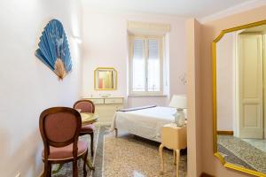 um quarto com uma cama, uma mesa e um espelho em Livorno Central Flat-2 min walk the Cathedral! em Livorno