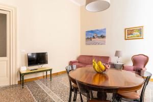 uma sala de estar com uma mesa e uma televisão em Livorno Central Flat-2 min walk the Cathedral! em Livorno