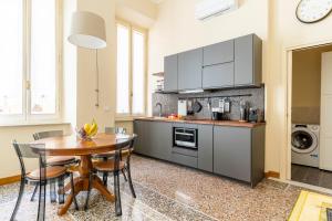 a kitchen with a wooden table and a dining room at Livorno Central Flat-2 min walk the Cathedral! in Livorno