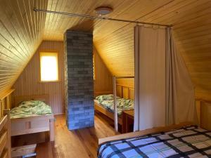 a attic bedroom with two beds and a fireplace at Jaś Roztocze in Nielisz