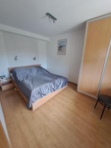 1 dormitorio con 1 cama y suelo de madera en Apartamenty Tercet, Apartament Kwartet, Apartament DUO, en Ustka