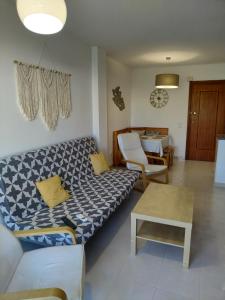 - un salon avec un canapé et une table dans l'établissement Apartamento en Playa de Gandia con piscina, à Gandía