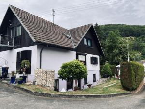 a white house with a black roof at 2 Ferienwohnungen Klenk in Gruibingen