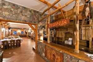 a restaurant with a bar with tables and chairs at Gród Piasta in Gąsawa