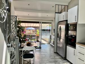 kuchnia i jadalnia ze stołem i krzesłami w obiekcie Naturiste Heliovillage Villa de Standing w Cap d'Agde