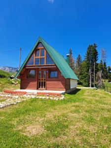 a cabin on a hill with a green roof at House SUN Z&B in Žabljak