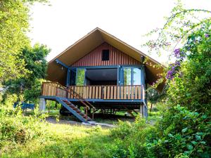 a small house with a porch and a deck at Jambo Mara Safari Lodge in Ololaimutiek
