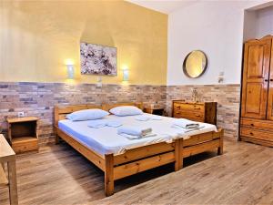 a bedroom with a large bed and a mirror at Zefyros Studios in Neos Marmaras