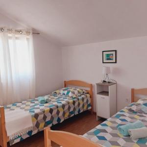 - une chambre avec deux lits et une table avec une lampe dans l'établissement Apartments Lavanda Vodice, à Vodice