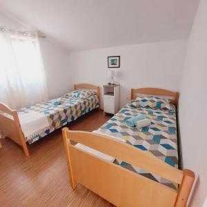 - une chambre avec deux lits et une table avec une lampe dans l'établissement Apartments Lavanda Vodice, à Vodice