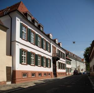 una fila de edificios con persianas verdes en una calle en Hotel Residenz am Königsplatz, en Speyer