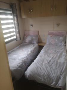 two beds sitting next to each other in a bedroom at Rest by the sea in Rhyl +4 photos