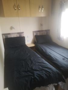 two beds sitting next to each other in a bedroom at Rest by the sea in Rhyl