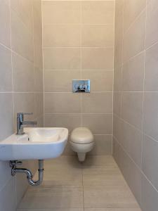 a bathroom with a toilet and a sink at See & You Familienwohnung mit Hotelanbindung in Pörtschach am Wörthersee