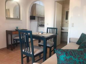 a dining table and chairs in a living room at Georgia's Comfort Studio in Perivolos