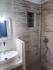 a bathroom with a sink and a shower at Georgia's Comfort Studio in Perivolos