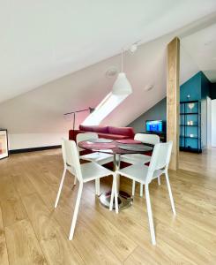 ein Esszimmer mit einem Tisch und weißen Stühlen in der Unterkunft SKY Apartments in Kaunas
