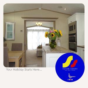 Seton Sands Holiday Home في Port Seton: مطبخ مع إناء من الزهور على منضدة