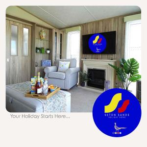 ein Wohnzimmer mit einem Sofa und einem TV in der Unterkunft Seton Sands Holiday Home in Port Seton
