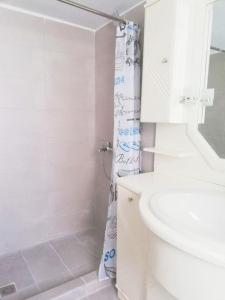 a white bathroom with a shower and a sink at Family Inn in Athens