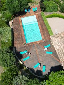 een uitzicht over een zwembad met blauwe stoelen bij Résidence Terra Théa in Propriano