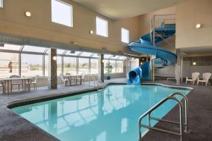 uma piscina interior com escorrega num edifício em Days Inn by Wyndham Regina Airport West em Regina