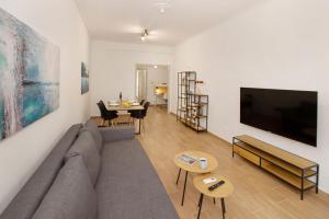 a living room with a couch and a flat screen tv at Beautiful apt near the sea by GHH in Athens